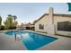 Relaxing pool with ladder entrance, surrounded by a concrete deck and lush greenery at 4689 Kristen Ln, Las Vegas, NV 89121