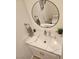 Bathroom with a granite counter, white cabinets, a round mirror, and a toilet at 5051 Fairmont St, Pahrump, NV 89061