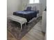 Bedroom featuring wood floors, a gray rug, a bed with white headboard, and a bench at 5051 Fairmont St, Pahrump, NV 89061