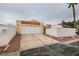 Single-story home featuring a two-car garage, desert landscaping, and a tile roof at 5151 Tennis Ct, Las Vegas, NV 89120