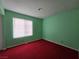 The bedroom has red carpet, green walls, and a window with blinds at 519 Fir St # G, Boulder City, NV 89005