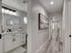 Hallway view of a bathroom featuring white cabinets and drawers, black hardware, and a quartz countertop at 5429 Painted Sunrise Dr, Las Vegas, NV 89149