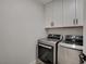 Laundry room featuring front loading washer and dryer and white cabinets for ample storage at 5429 Painted Sunrise Dr, Las Vegas, NV 89149