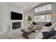 Cozy living room with fireplace, large windows, high ceilings, and comfortable seating arrangements at 5429 Painted Sunrise Dr, Las Vegas, NV 89149