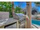 Outdoor kitchen featuring a stainless steel gas grill and mini fridge, perfect for entertaining by the pool at 5429 Painted Sunrise Dr, Las Vegas, NV 89149