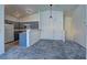 Modern kitchen with gray cabinetry, white appliances, and access to upper level at 5457 Jackpot Winner Ln # 101, Las Vegas, NV 89122