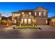 Exterior shot of a two-story home featuring manicured landscaping, a multi-car garage and neutral paint at 5523 Kyle Peak Ct, Las Vegas, NV 89135