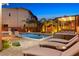 Inviting backyard pool with lounge chairs, mature trees, and a covered seating area at 5523 Kyle Peak Ct, Las Vegas, NV 89135