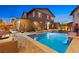 Backyard pool and patio area features a cozy seating area with string lights and built-in spa at 5523 Kyle Peak Ct, Las Vegas, NV 89135