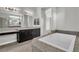 Elegant bathroom featuring a soaking tub, dual sinks, vanity, and granite countertops at 6130 Pebble Glen, Las Vegas, NV 89149