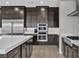 Modern kitchen with stainless steel appliances, dark cabinets, and a tiled backsplash at 6130 Pebble Glen, Las Vegas, NV 89149