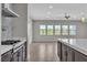 Open-concept kitchen with stainless steel appliances, dark cabinets, and plenty of natural light at 6130 Pebble Glen, Las Vegas, NV 89149