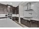 Stylish kitchen featuring dark wood cabinets, stainless steel appliances, and a mosaic tile backsplash at 6130 Pebble Glen, Las Vegas, NV 89149