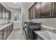 Well-equipped laundry room with modern washer/dryer, sink, and ample cabinet space at 6130 Pebble Glen, Las Vegas, NV 89149