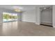 Spacious living room with tile flooring, modern light fixture, and a sliding glass door at 6130 Pebble Glen, Las Vegas, NV 89149