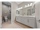 Elegant bathroom featuring double sinks, white cabinetry, and a glass-enclosed shower for a spa-like experience at 6192 Lautman Ridge Ct, Las Vegas, NV 89141