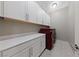Functional laundry room with ample storage, sleek countertops, and modern red washer and dryer units at 6192 Lautman Ridge Ct, Las Vegas, NV 89141