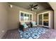 Inviting covered patio with comfortable seating, a ceiling fan, and views of the well-manicured backyard at 6192 Lautman Ridge Ct, Las Vegas, NV 89141