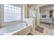 Bright bathroom featuring a large tub with glass block window at 6736 Sugarbird Ct, North Las Vegas, NV 89084