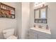 Charming powder room features a sink with storage, a decorative mirror, and stylish wall decor at 6736 Sugarbird Ct, North Las Vegas, NV 89084