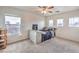 Bright bedroom with three windows, carpeted floor, and ceiling fan at 6736 Sugarbird Ct, North Las Vegas, NV 89084