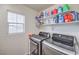 Convenient laundry room equipped with modern washer and dryer and storage shelves at 6736 Sugarbird Ct, North Las Vegas, NV 89084