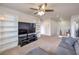 Second view of the spacious living room with plush carpet, built in shelves, and a ceiling fan at 6736 Sugarbird Ct, North Las Vegas, NV 89084