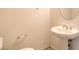 Powder room featuring a pedestal sink, round mirror, and white fixtures at 6741 Philippe Allen Ave, Las Vegas, NV 89110