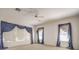 Large bedroom with neutral carpet, ceiling fan and several large windows at 6741 Philippe Allen Ave, Las Vegas, NV 89110