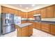Spacious kitchen with stainless steel appliances, wood cabinets and tile flooring at 6741 Philippe Allen Ave, Las Vegas, NV 89110