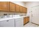 Functional laundry room with washer, dryer, sink, and ample cabinet storage at 6741 Philippe Allen Ave, Las Vegas, NV 89110