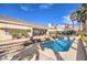 Serene backyard showcasing a pool and stone-paved patio, complemented by lush greenery and awning-covered space at 6741 Philippe Allen Ave, Las Vegas, NV 89110