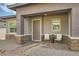 Inviting front entrance with brick accents, a cozy seating area and manicured plants at 758 Marigold Sunrise St, Henderson, NV 89011