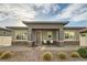 Inviting home exterior with covered porch, manicured landscaping, and neutral color scheme at 758 Marigold Sunrise St, Henderson, NV 89011