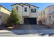 Two-story home with stucco siding, dark roof, and two car garage at 7730 Peace Lily Ct, Las Vegas, NV 89139