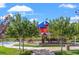 Playground in a well-manicured park setting featuring a colorful playset with trees and walkways at 9032 Skye Canyon Ranch St, Las Vegas, NV 89166