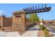 Stone entrance to the Aviano community with manicured landscaping and a modern pergola at 9032 Skye Canyon Ranch St, Las Vegas, NV 89166