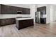 Modern kitchen featuring dark wood cabinets, an island, and stainless steel appliances at 9032 Skye Canyon Ranch St, Las Vegas, NV 89166