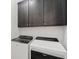 Laundry room with washer and dryer and dark cabinets for storage at 9032 Skye Canyon Ranch St, Las Vegas, NV 89166