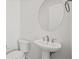 This is a half bathroom with a pedestal sink, toilet, and oval mirror at 9032 Skye Canyon Ranch St, Las Vegas, NV 89166
