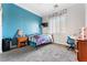 Bright bedroom featuring blue accent wall, modern fixtures and large window providing natural light at 10129 Elk Valley St, Las Vegas, NV 89178