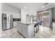 Modern kitchen with stainless steel appliances, granite countertops, island with bar stools, and ample cabinet space at 10129 Elk Valley St, Las Vegas, NV 89178