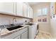 Laundry room with granite countertops, white cabinetry, a sink, and front-loading washer and dryer at 10129 Elk Valley St, Las Vegas, NV 89178