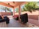 Covered patio with stone flooring, comfortable seating, and a built-in grill, perfect for outdoor entertaining at 10129 Elk Valley St, Las Vegas, NV 89178