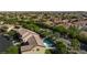 Aerial view of a home with a private pool in a suburban neighborhood with lush greenery and a scenic mountain backdrop at 10288 Grizzly Forest Dr, Las Vegas, NV 89178