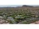 An aerial view showcases a dense neighborhood surrounded by lush green trees and desert mountains at 10288 Grizzly Forest Dr, Las Vegas, NV 89178