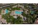A dynamic aerial view displays a resort style community pool area, basketball court, and playground at 10288 Grizzly Forest Dr, Las Vegas, NV 89178