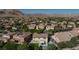Aerial view of suburban homes nestled in a desert landscape, featuring mature trees and glimpses of private pools at 10288 Grizzly Forest Dr, Las Vegas, NV 89178