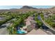 Aerial view of a suburban home with a private pool and backyard oasis with surrounding desert landscape and greenery at 10288 Grizzly Forest Dr, Las Vegas, NV 89178