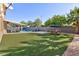Expansive backyard with well-maintained artificial turf, stylish patio furniture, and a refreshing pool area at 10288 Grizzly Forest Dr, Las Vegas, NV 89178